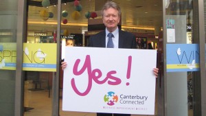 A man outside Fenwick holding a sign that says Yes! Canterbury Connected BID