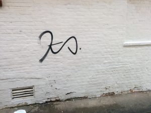 Graffiti on a white brick wall on Whitehorse Lane