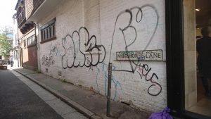 Graffiti on a white brick wall on Whitehorse Lane