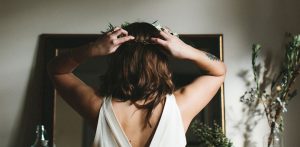 A bride looking in the mirror and putting a flower crown on her head