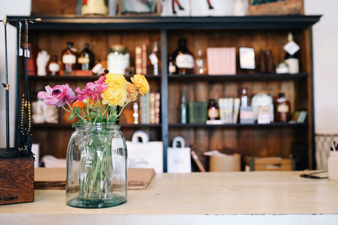 A glass jar of flowers on a countertop
