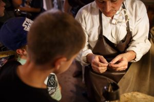 Two young boys admiring a mans craftsmanship