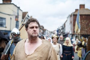 A man dressed in medieval attire in the medieval pageant