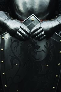 A knight holding a shield with both hands in a resting position
