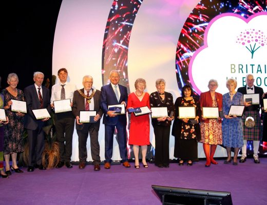 Britain in Bloom award winners taking a celebratory photo together, all holding their award certificates