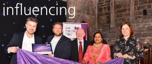 A photo of Some people posing for a picture at a Purple Flag event with influencing over it in white text
