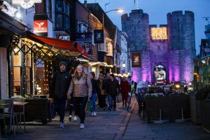 Some people walking down Canterbury high street in the evening