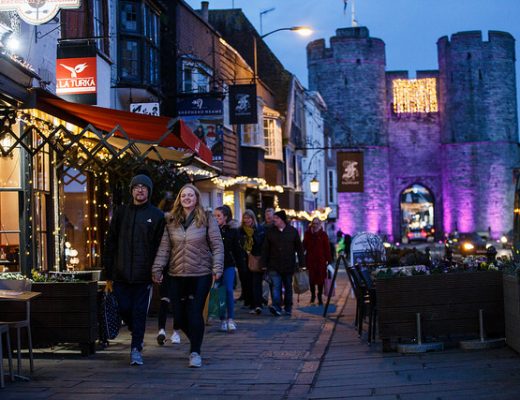 Some people walking down Canterbury high street in the evening