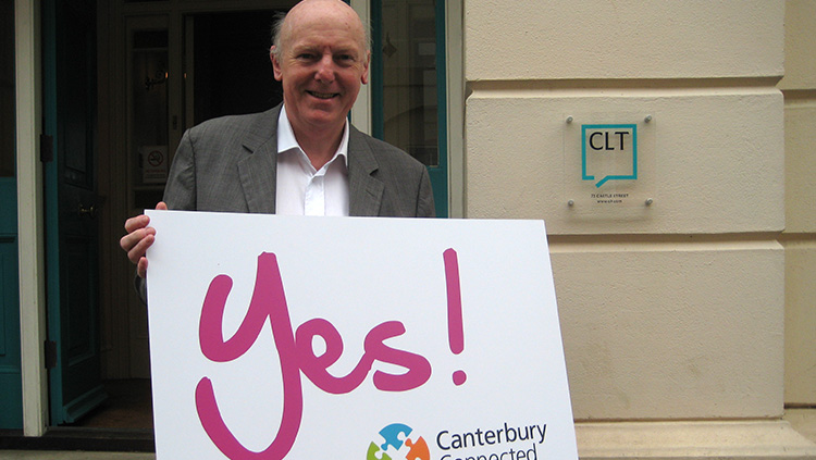 A man outside CLT holding a sign that says Yes! Canterbury Connected BID