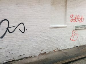 Graffiti on a white brick wall on Whitehorse Lane