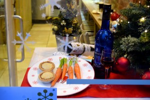 Some mince pies and carrots on a plate next to a bottle of sherry