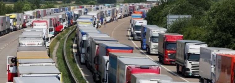 A motorway lined with lorries and vans in a traffic jam