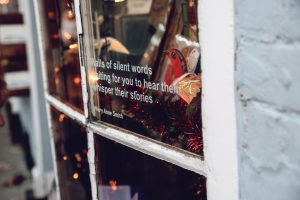 Walls of silent words waiting for you to hear them whisper their stories - Mary Anne Smith quote on a Chaucer Bookshop window