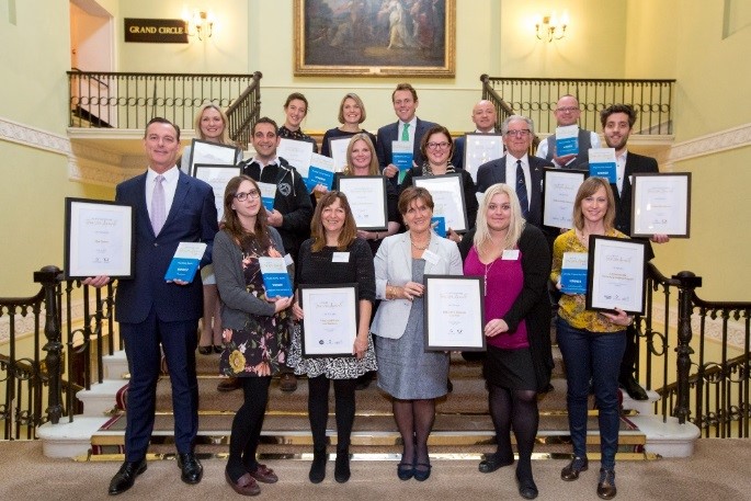 A large group of people posing for a photo with award certificates