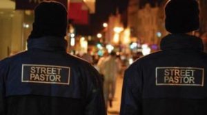 Two street pastors walking with their backs to the camera