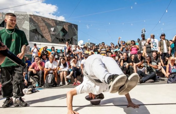 A street dancer performing in front of a crowd of people