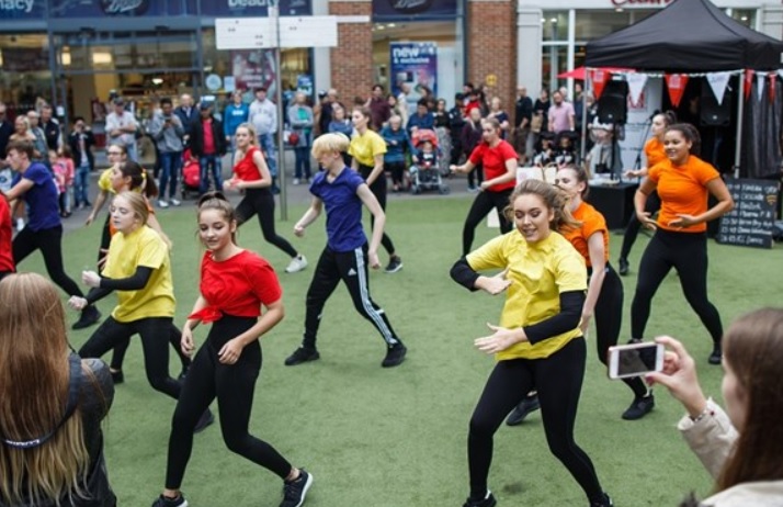 Some young people in coloured t-shirts and sports gear dancing at Canterbury Festival