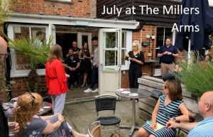 A photo of a room of people socialising, with text above it that reads July at The Millers Arms