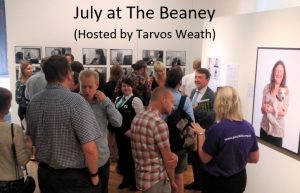 A photo of a room of people socialising, with text above it that reads July at The Beaney (hosted by Tarvos Weath)