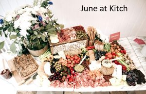 Some flowers and a charcuterie board, with text that reads June at Kitch