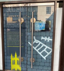 The Cathedral Quarter poster in a glass door
