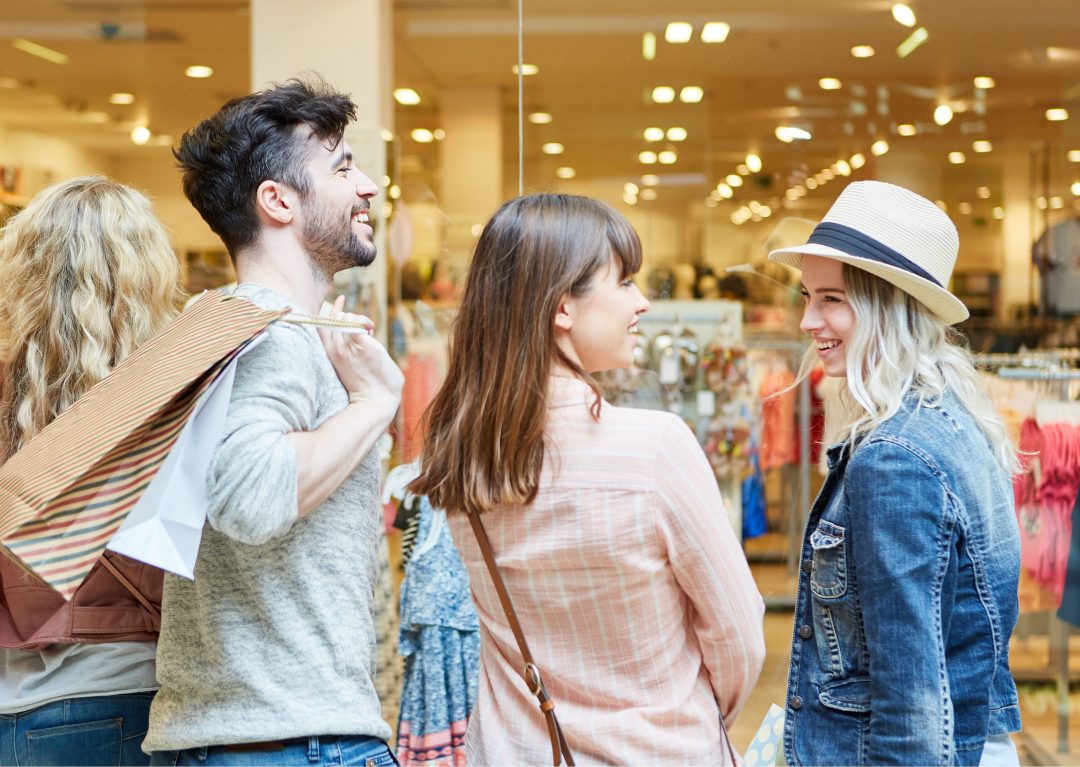 A photo of three students shopping and smiling