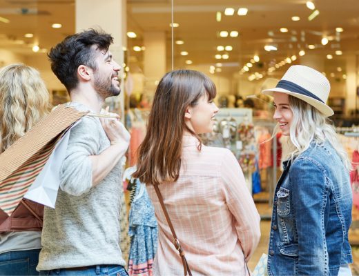 A photo of three students shopping and smiling