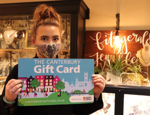 A woman holding an enlarged novelty Canterbury Gift Card