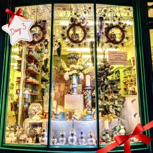 A shop window decorated with wreaths, snowmen and a christmas tree