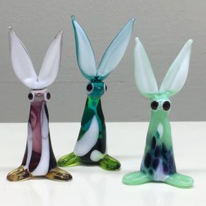 A photo of three glass art figurines