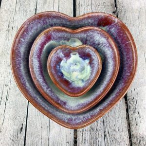 Three heart shaped bowls of varying sizes, stacked within each other