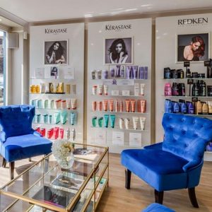 A photo of a wall of hair products with two chairs in front of it in Stone salon