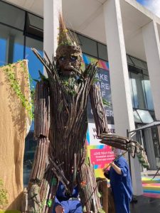 A photo of a statue of a tall wooden man at the Marlowe Outdoor Festival