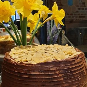 A photo of a cake from Tiny Tim's Tearoom, with some daffodils in the background