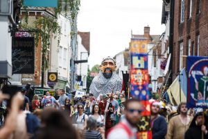 A photo of people walking the Medieval Pageant and Trail in a Canterbury street