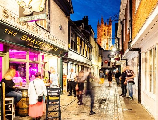 A photo of a Canterbury street at night, with The Shakespeare pub in the foreground and Canterbury Cathedral in the background