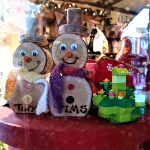 A photo of two little wooden snowmen and some Lego in a shop window