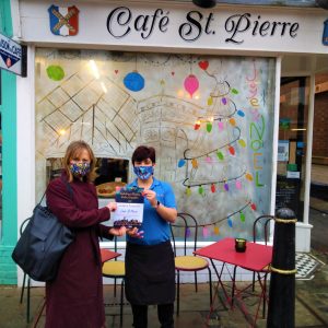 A photo of two women standing and smiling outside of Café St. Pierre