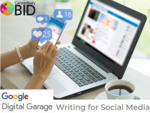 A photo of a person holding a smart phone in front of a laptop with the Canterbury BID logo, the Google logo and text that reads digital garage writing for social media