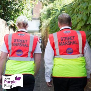 A photo of two walking street marshals' backs