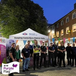 A photo of a group of people, including police officers, under a kent police gazebo posing for ATCM purple flag