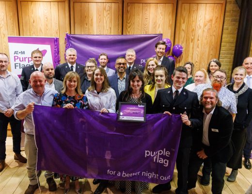A group of people representing purple flag and smiling