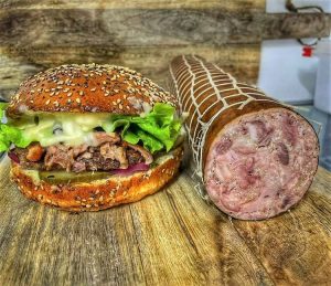 A photo of a burger and some sausage meat