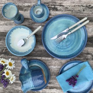 Some blue plates and crockery on a wooden table